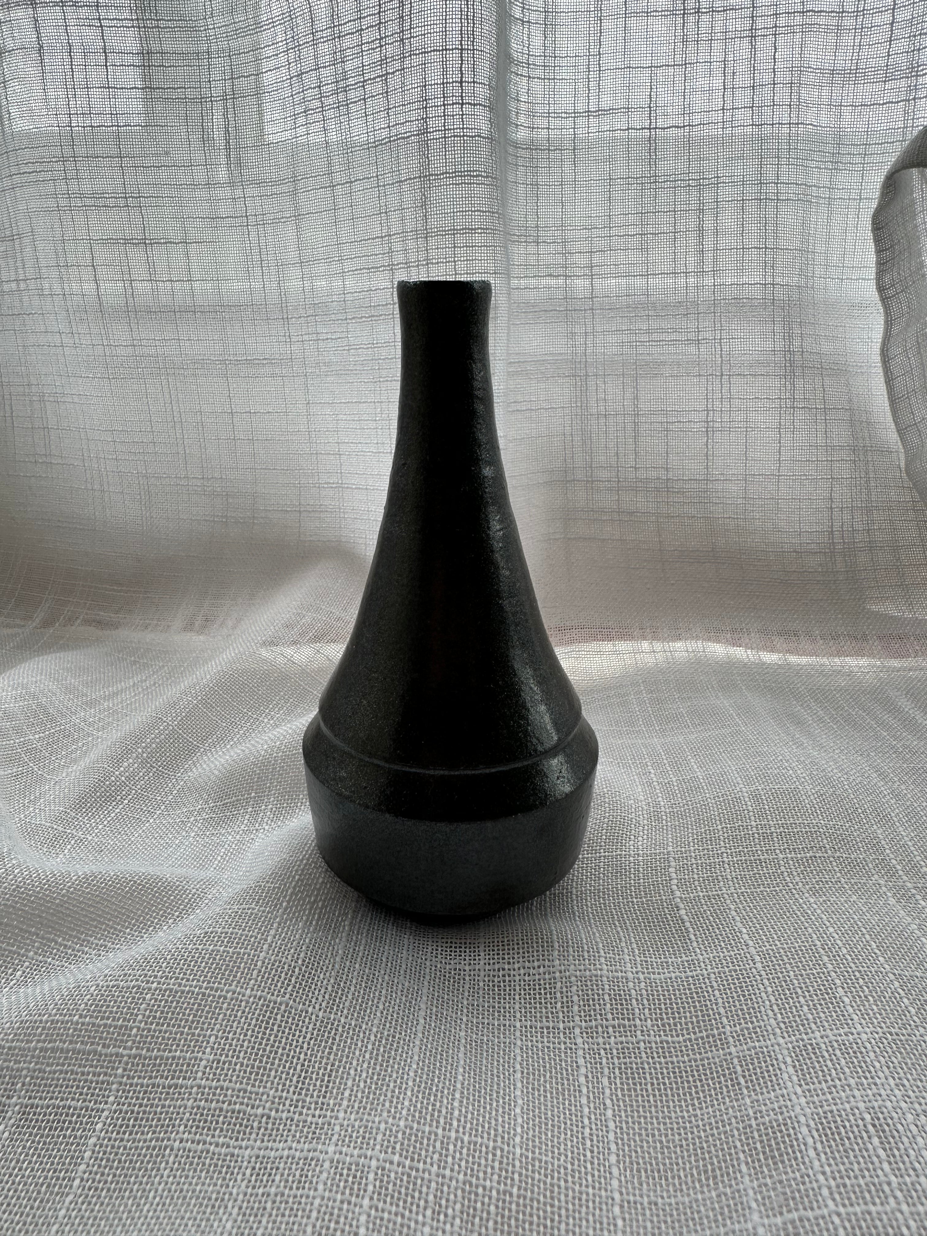 Black vase on a textured gray surface