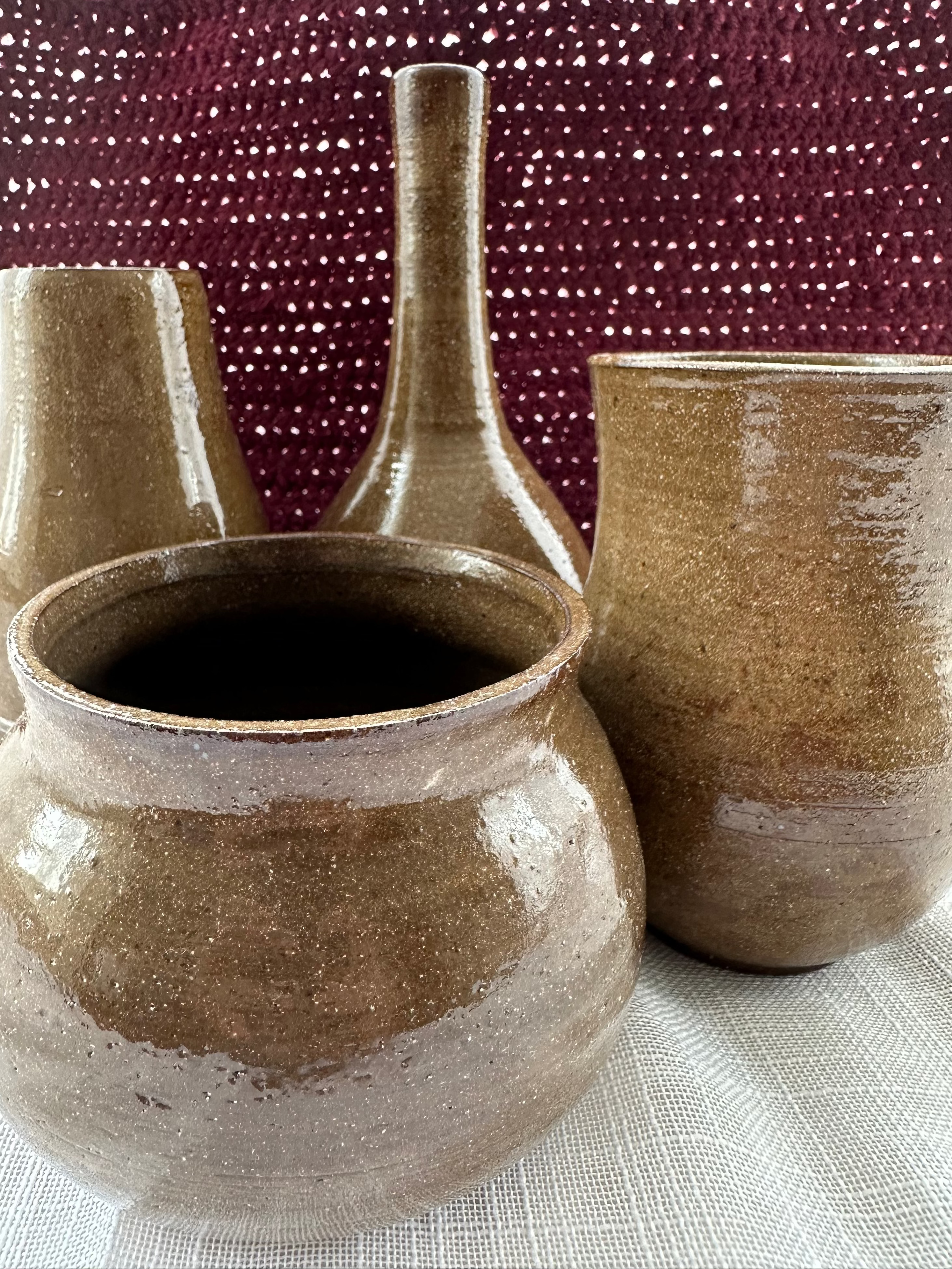 Set of ceramic pots with a textured surface on a fabric background