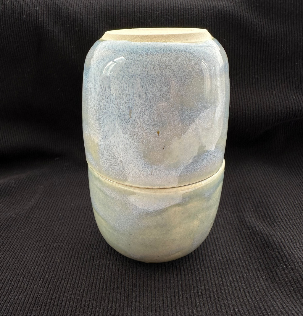 Ceramic container with marbled design on a black background