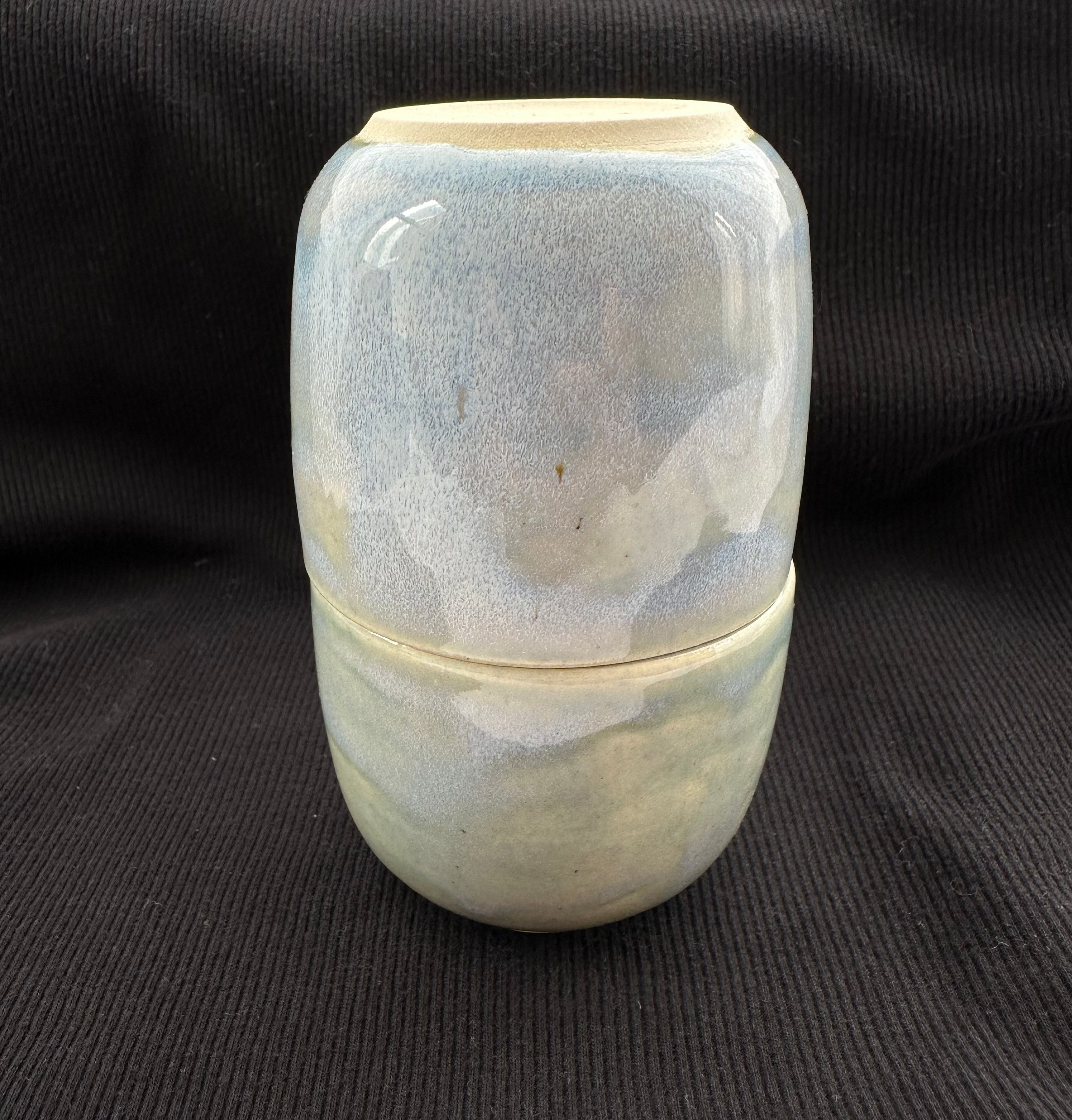 Ceramic container with marbled design on a black background