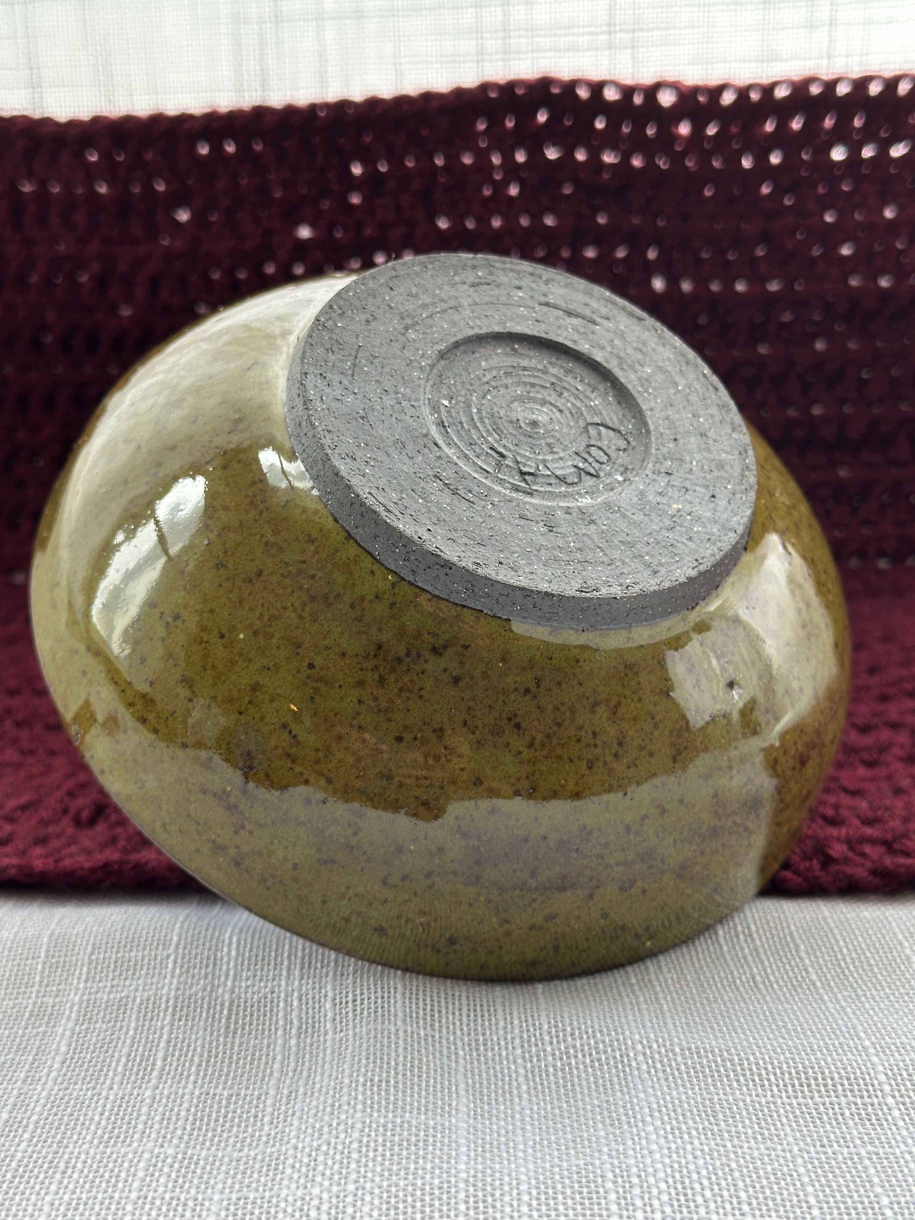 Ceramic bowl with a dark gray exterior on a textured surface