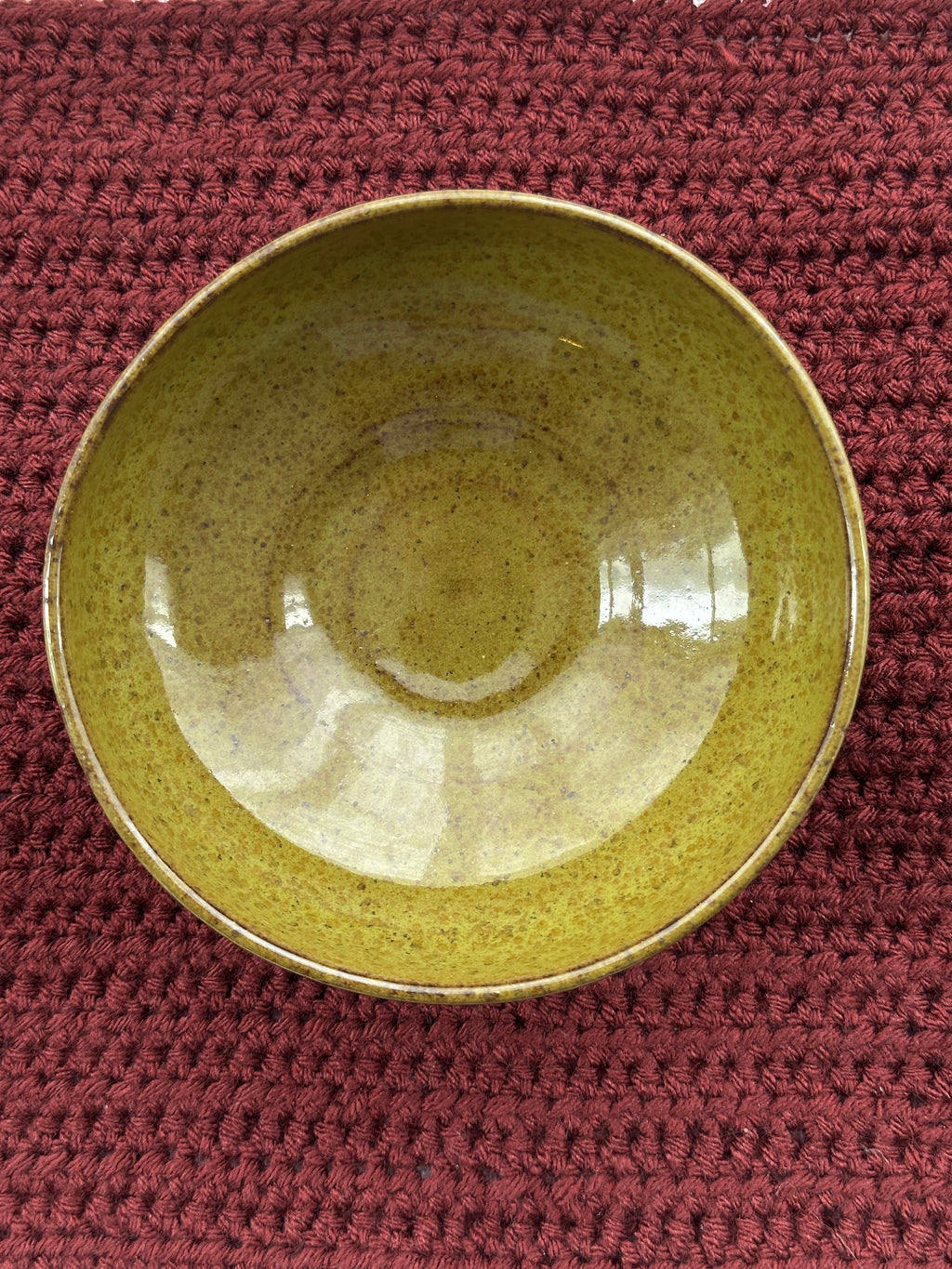 Green ceramic bowl on a textured red surface