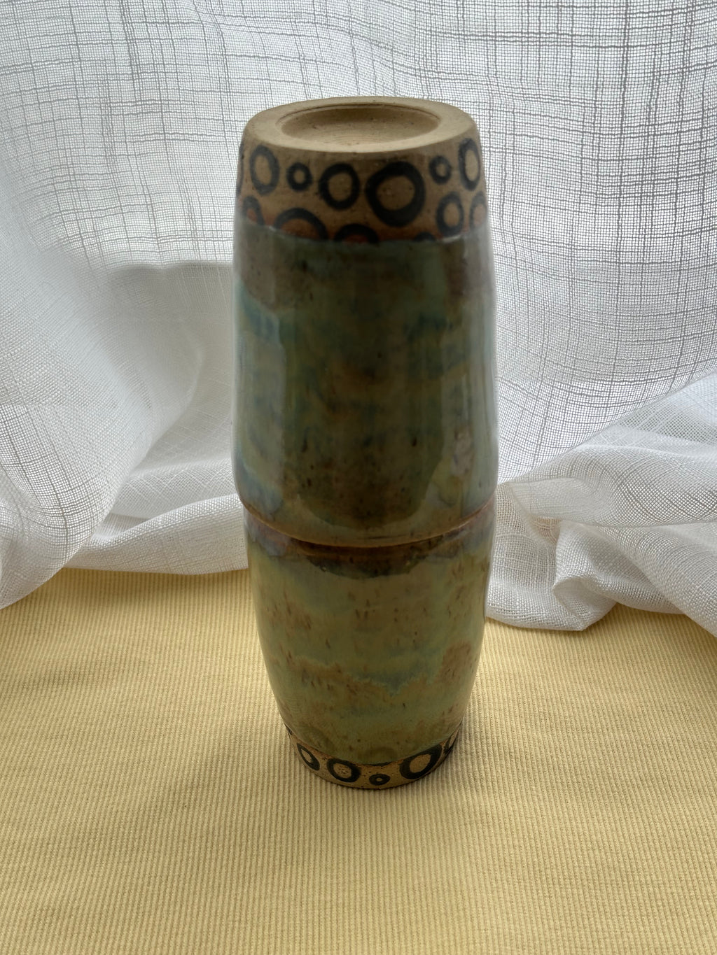 Ceramic cups stacked with decorative patterns on a textured surface