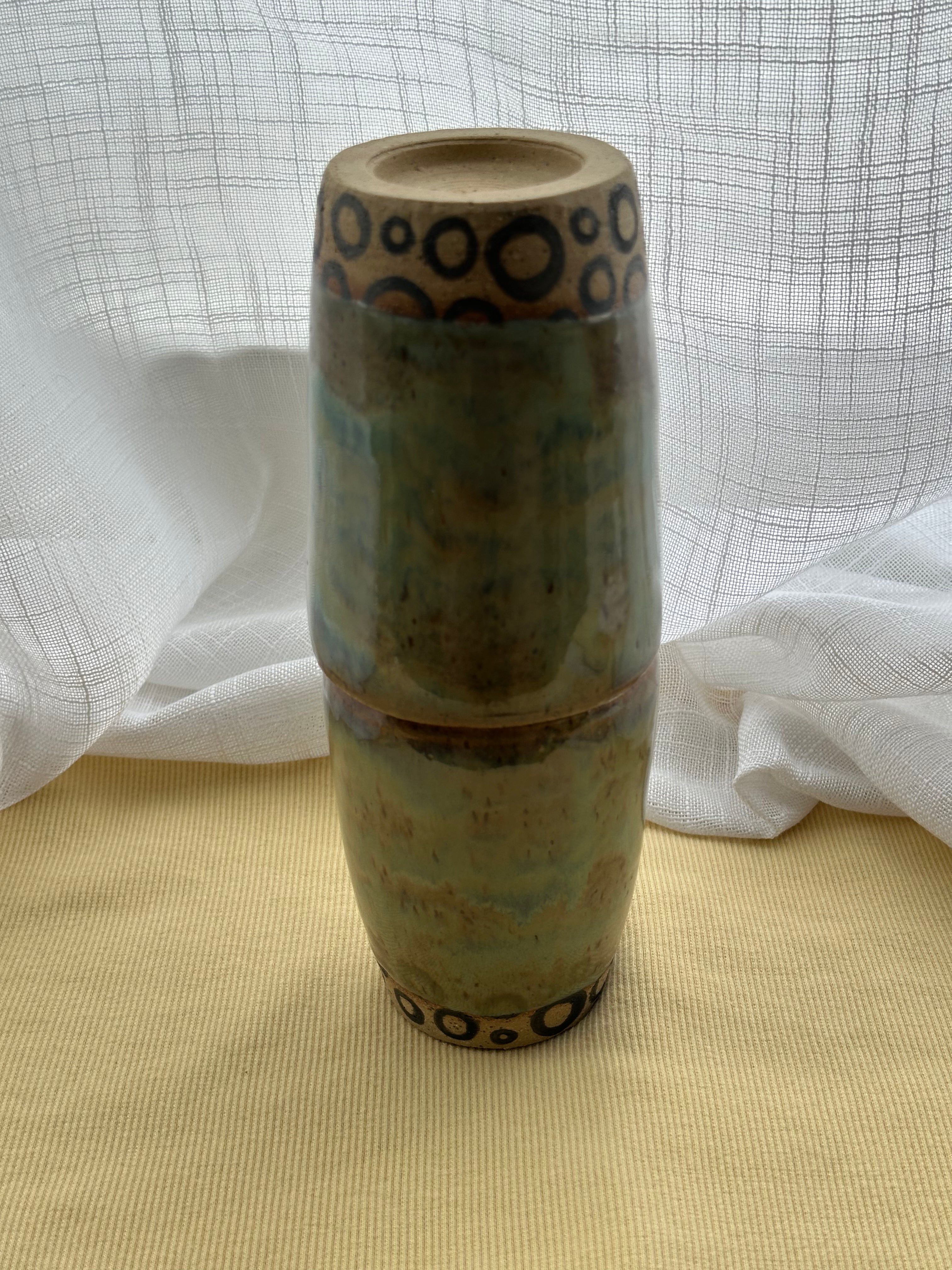 Ceramic cups stacked with decorative patterns on a textured surface